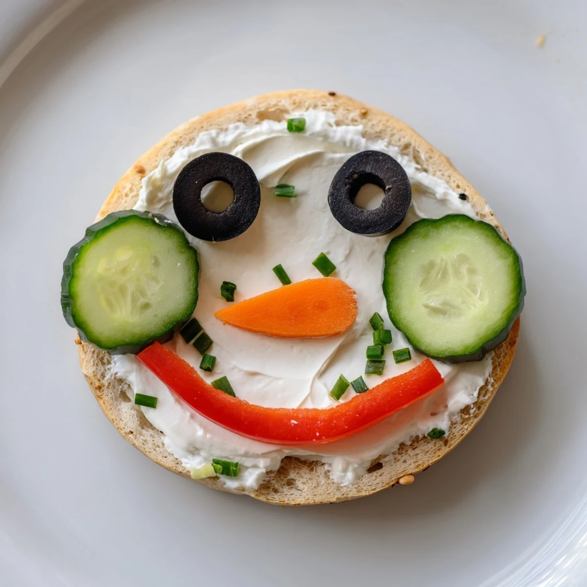 Snowman mini bagel sandwiches with smiling olive eyes and carrot noses, ready to eat.