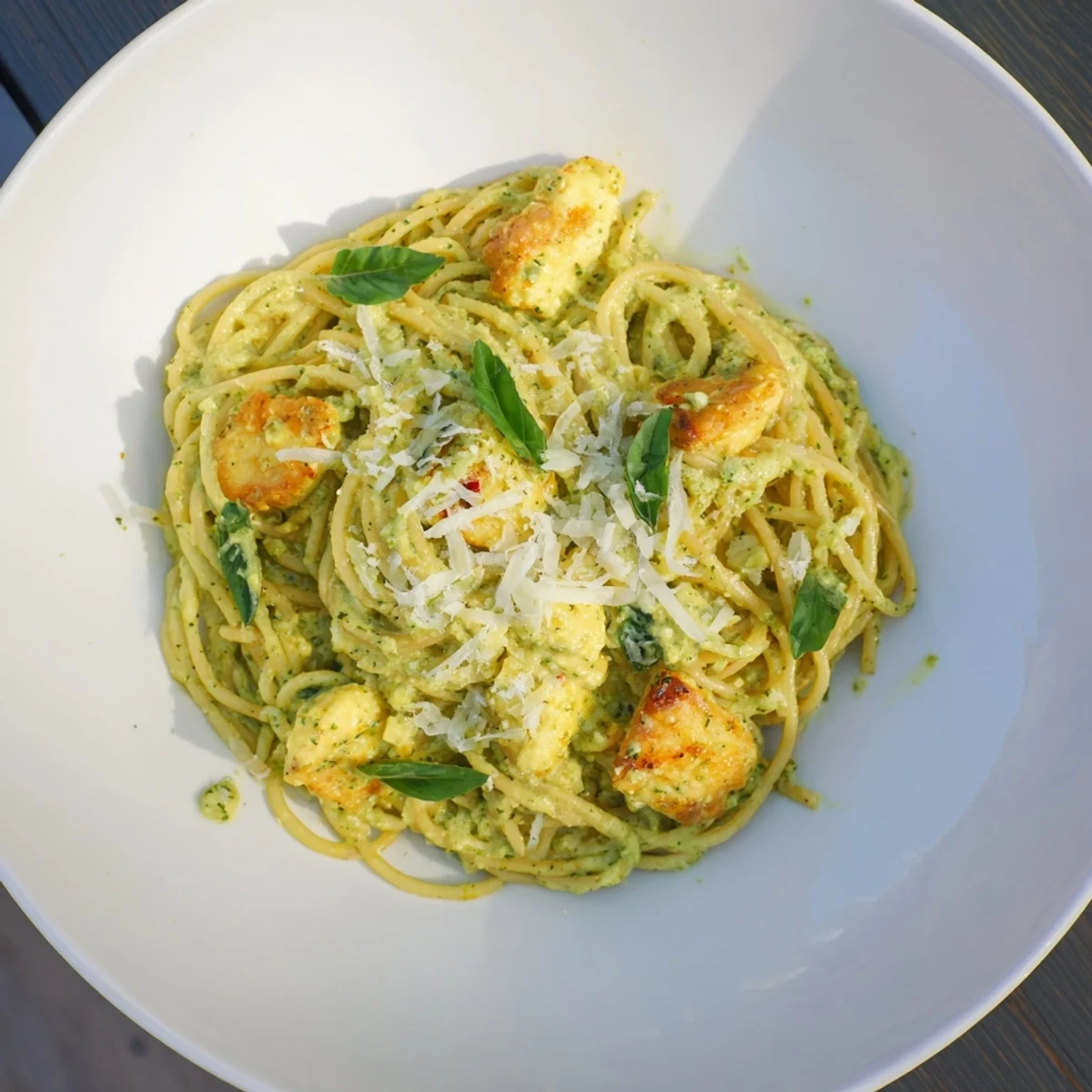 Golden chicken nestled in pesto egg pasta, a comforting Italian-American dish, ready to savor.