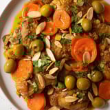 A close-up of a bubbling Moroccan Tagine Chicken stew, with visible apricots, glistening broth.