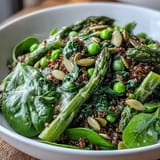 Close-up of a freshly prepared Spring Green Bowl featuring crisp green beans, wilted spinach, and a glistening lemon dressing.