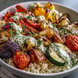 Hearty Rainbow Roasted Vegetable Bowl served warm in a white bowl, with golden, caramelized vegetables and a fresh green herb drizzle.