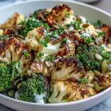 Roasted Brassica Bowl with golden broccoli, cauliflower, and Brussels sprouts over fluffy quinoa, drizzled with creamy tahini-lemon dressing.