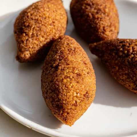 Golden-brown Lebanese Kibbeh, crisp on the outside, showcasing its savory meat and bulgur filling.