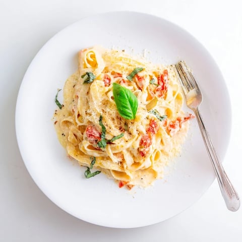 Roasted Garlic Pasta Sauce in a creamy bowl, garnished with fresh basil and grated Parmesan, steaming softly.