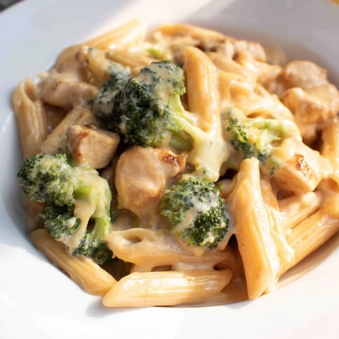 Creamy Chicken Broccoli Cheddar Pasta in a skillet, with tender chicken pieces and bright green broccoli florets in a velvety cheddar sauce.  