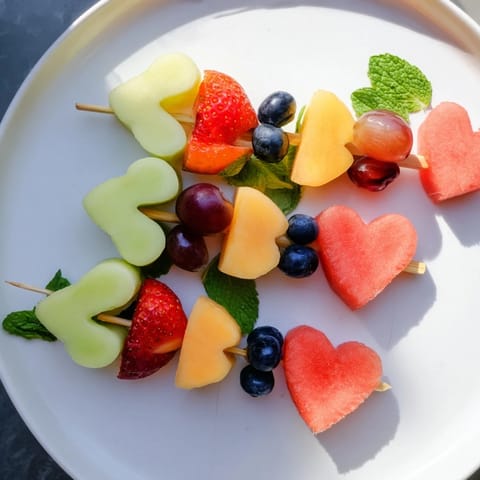 Delicious Berry Good Heart Fruit Skewers, a colorful arrangement of fresh fruit on skewers, ready to eat!