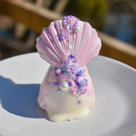 White chocolate-dipped Mignardises Queue de Sirène, adorned with shimmering sprinkles, offer refined sweetness.