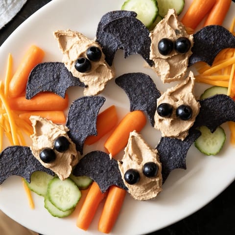 A festive Spooky Bat Bean Dip Platter filled with creamy black bean dip, perfect for Halloween fun.