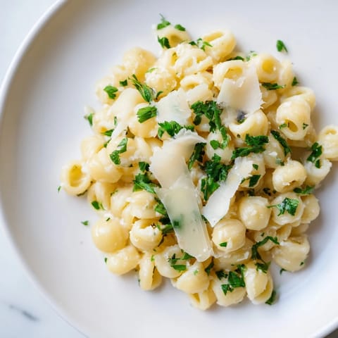 The finished ditalini pasta, creamy garlic sauce swirled around the pasta with fresh parsley.