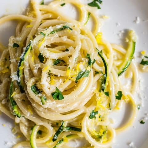 Tender zucchini noodles and pasta tossed in a vibrant lemon garlic butter sauce with melted Parmesan.