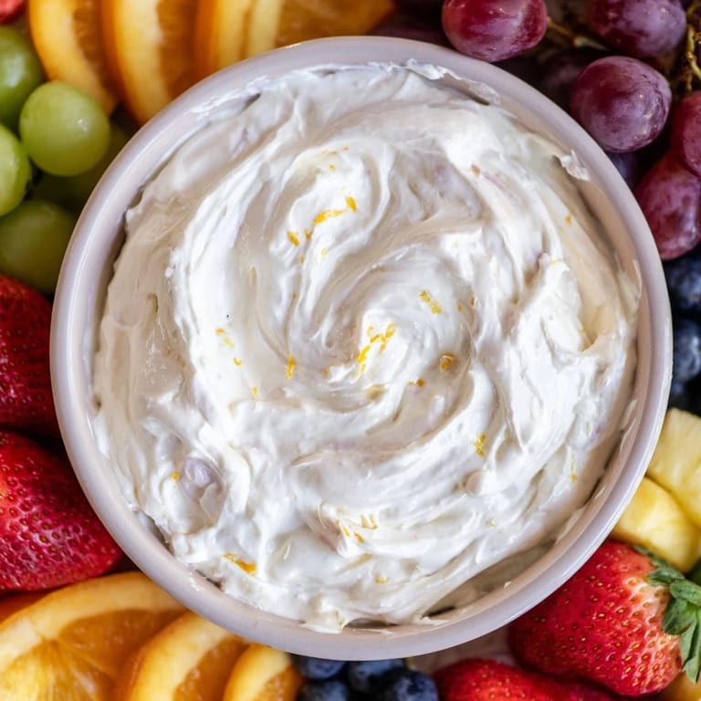 Fresh fruit surrounds a central bowl of creamy cream cheese fruit dip, perfect for gatherings and snacking.