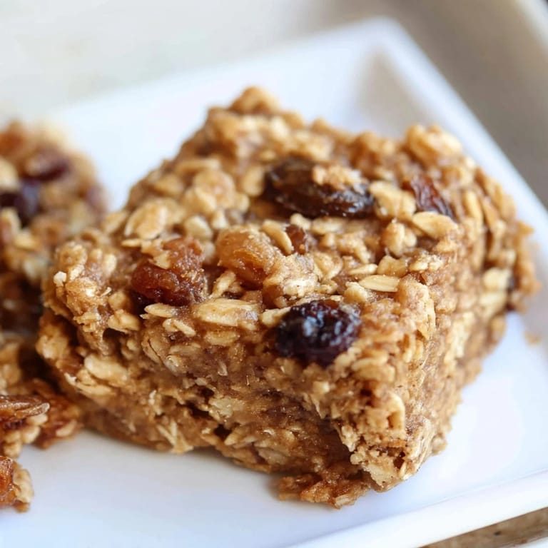 Deliciously moist maple cinnamon oatmeal bars, served warm—a perfect, grab-and-go snack.