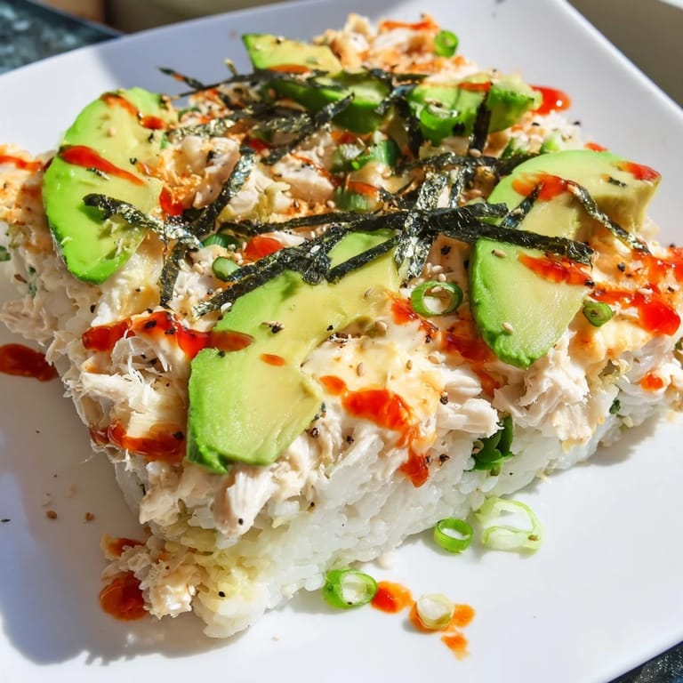 A close-up of a bubbling Chicken Sushi Bake, topped with melted cheese, ready to serve.