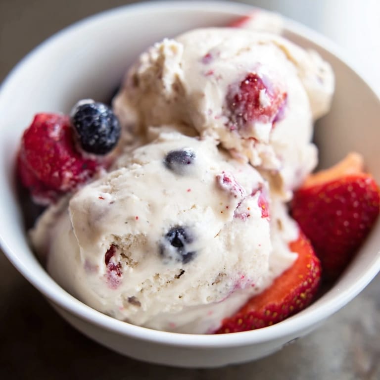 Scoops of homemade Cottage Cheese Ice Cream, looking smooth, are ready to be served in a bowl.