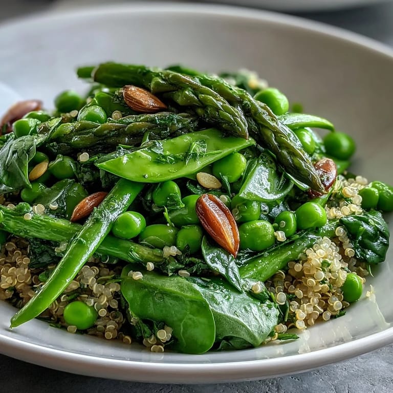 Serving suggestion of a nutritious Spring Green Bowl, garnished with fresh mint and served on a rustic wooden table.