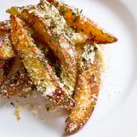 Golden Rosemary Parmesan Potato Wedges, ready to eat, with crispy edges and melted cheese.