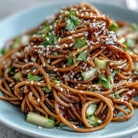 Chilled soba noodle salad with sesame ginger dressing, vibrant and refreshing.